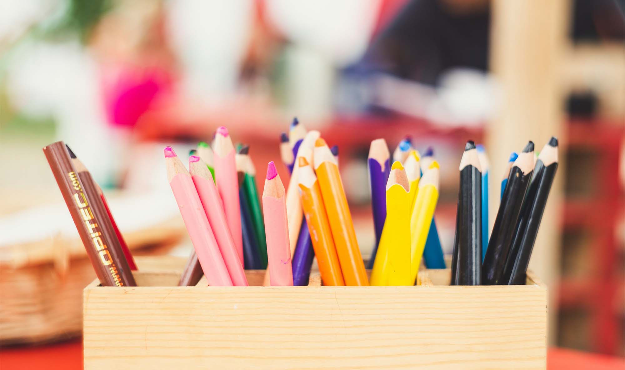 Several coloring pencils sit in a box.